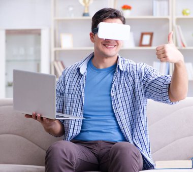 Evde sanal gerçeklik gözlükleriyle serbest çalışan bir öğrenci.