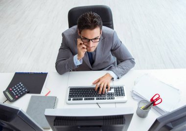 Genç işadamı masasında çalışıyor.