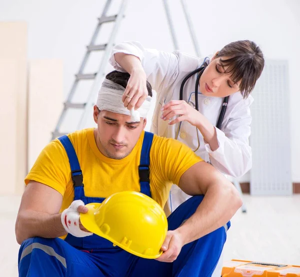 Trabalhador com cabeça ferida e médico — Fotografia de Stock