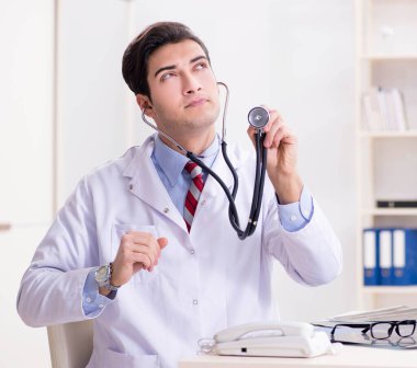 Hastane odasında çalışan yakışıklı genç bir doktor.