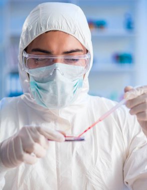 Laboratuvar asistanı hastanede kan örneklerini test ediyor.