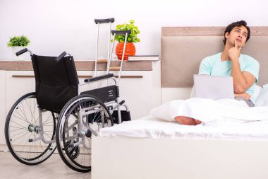 Genç yakışıklı engelli adam evde iyileşiyor.