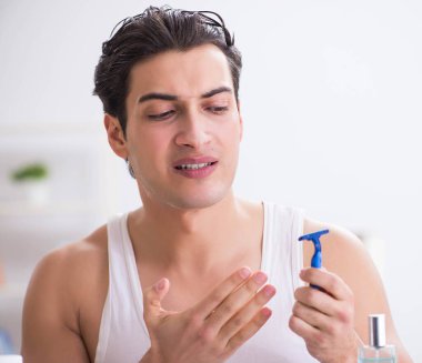 Genç yakışıklı adam sabah erkenden tıraş oluyor.