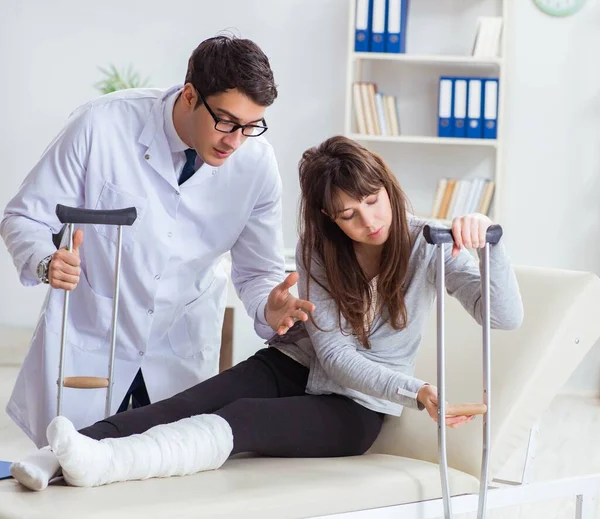 Lekarz badający pacjenta ze złamaną nogą — Zdjęcie stockowe