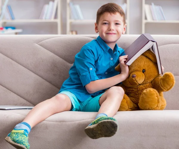 Evde kitap okuyan küçük bir çocuk. — Stok fotoğraf