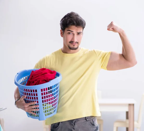 Yakışıklı koca evde çamaşır yıkıyor. — Stok fotoğraf
