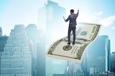 İş adamı 100 dolarlık banknotla uçuyor.