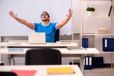 Sınıftaki genç erkek öğrenci.