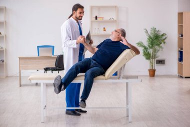 Yaşlı erkek hasta genç erkek doktor radyolojisti ziyaret ediyor.