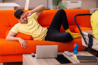 Genç adam evde yeni doğan çocuğa bakıyor.