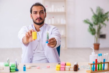 Genç erkek kimyager laboratuarda sabun test ediyor.