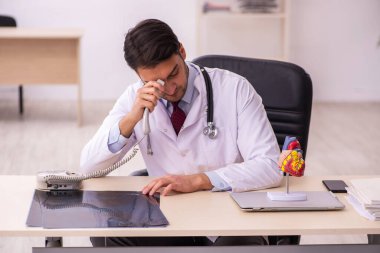 Klinikte çalışan genç bir erkek kardiyolog.
