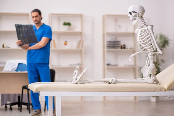 Hombre joven radiólogo médico y paciente esqueleto en la clínica — Foto de Stock