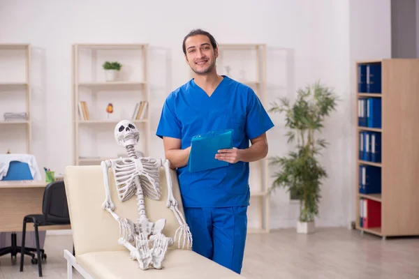 Jovem médico e paciente esqueleto na clínica — Fotografia de Stock