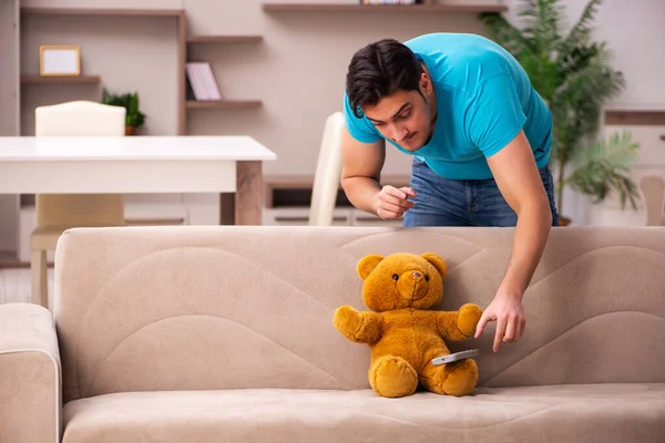 Young man sitting with bear toy at home — Stock Photo, Image