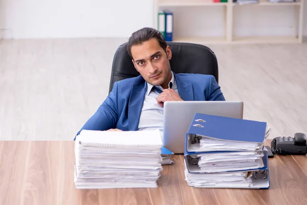 Joven empleado masculino infeliz con el trabajo excesivo — Foto de Stock