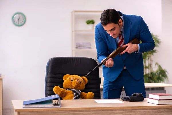 Giovane dipendente maschio e il suo capo orso giocattolo in concetto divertente — Foto Stock