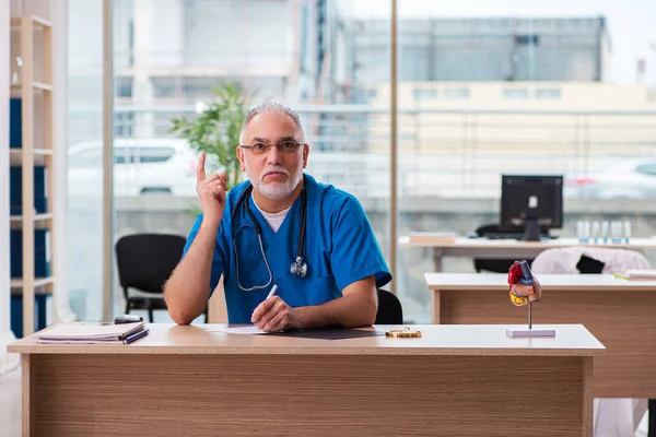 Vecchio medico di sesso maschile che lavora in clinica — Foto Stock