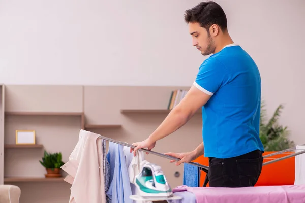 Jonge man man doet strijken thuis — Stockfoto