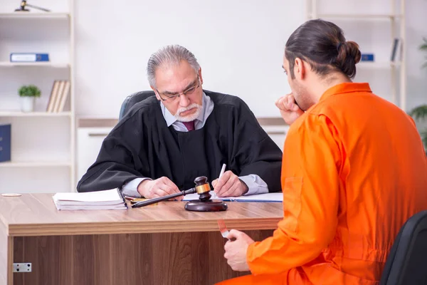 Velho juiz masculino reunião com jovem cativo no tribunal — Fotografia de Stock