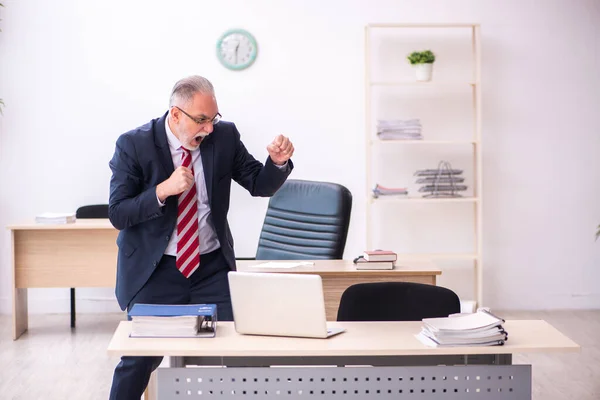 Velho empresário empregado sentado no escritório — Fotografia de Stock