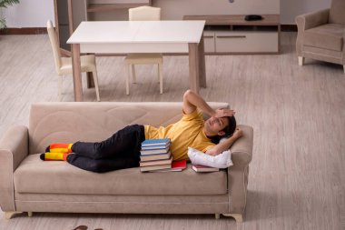 Evde sınava hazırlanan genç bir erkek öğrenci.