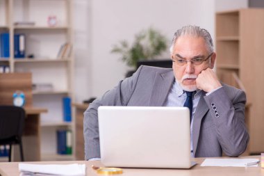 Ofiste çalışan yaşlı bir erkek.