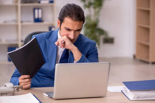 Junge männliche Angestellte sitzen im Büro — Stockfoto