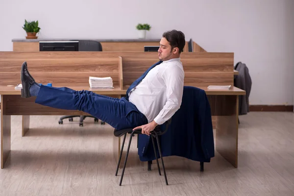 Empleado joven de negocios haciendo ejercicios deportivos en el lugar de trabajo —  Fotos de Stock