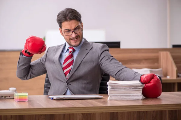 Junge männliche Angestellte trägt am Arbeitsplatz Boxhandschuhe — Stockfoto