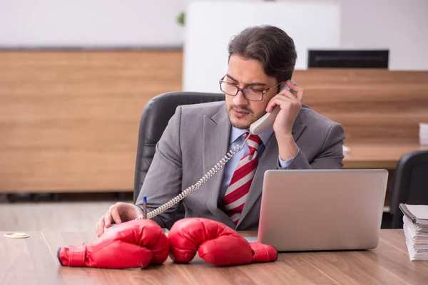 Junge männliche Angestellte trägt am Arbeitsplatz Boxhandschuhe — Stockfoto