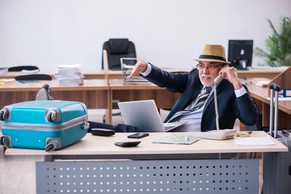 Gammal manlig anställd som förbereder sig för resa på kontoret — Stockfoto