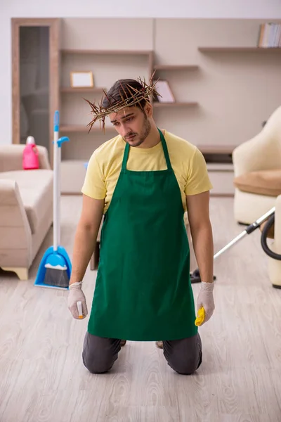 Jovem empreiteiro masculino vestindo grinalda espinhosa na cabeça limpeza th — Fotografia de Stock