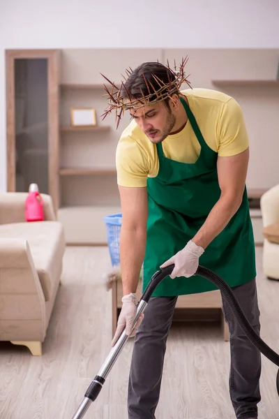 Young male contractor wearing prickly wreath on head cleaning th — Stock Photo, Image