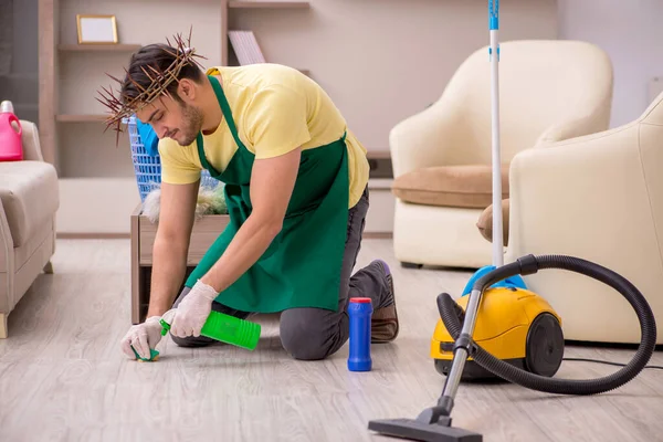 Jonge mannelijke aannemer draagt stekelige krans op het hoofd schoonmaken th — Stockfoto