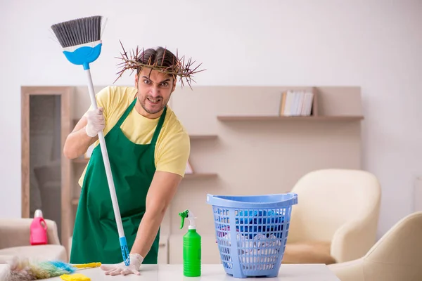 Jovem empreiteiro masculino vestindo grinalda espinhosa na cabeça limpeza th — Fotografia de Stock