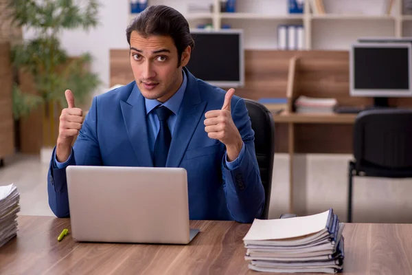 Jeune employé masculin et beaucoup de travail au bureau — Photo