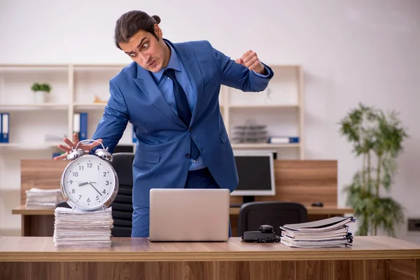 Joven empleado masculino en concepto de gestión del tiempo — Foto de Stock