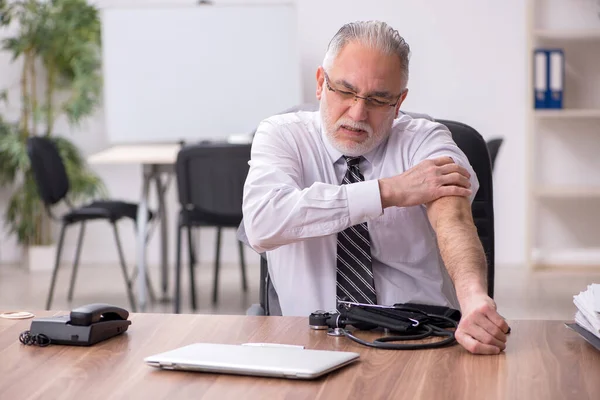 Empleado varón mayor que sufre en el lugar de trabajo — Foto de Stock