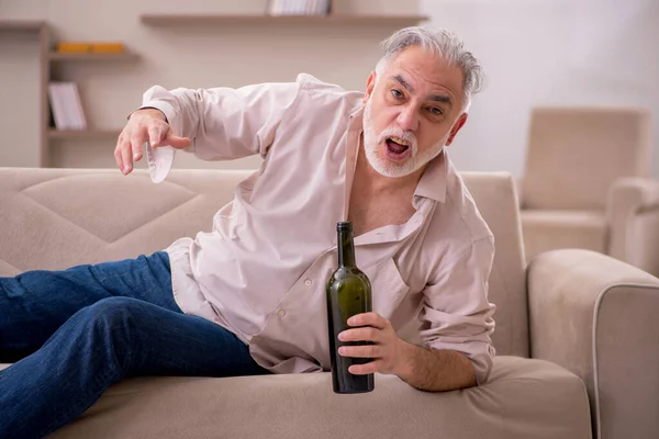 Старик пьет алкоголь дома — стоковое фото