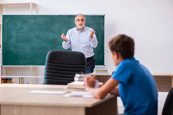 Yaşlı erkek öğretmen ve okul çocuğu sınıfta. — Stok fotoğraf