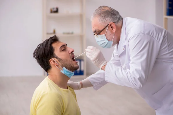 Young male patient visiting old male doctor otorhinolaryngologis — Stock Photo, Image