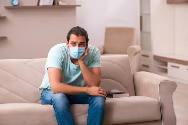 Młody mężczyzna siedzi w domu podczas pandemii — Zdjęcie stockowe