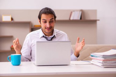 Genç erkek çalışan salgın sırasında evden çalışıyor.