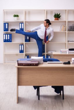 Mola sırasında spor yapan genç erkek çalışanlar.