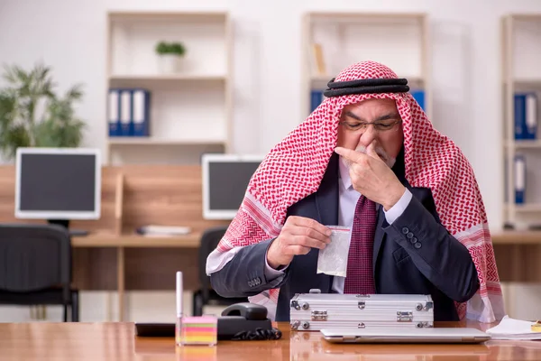 Hombre de negocios árabe viejo vendiendo narcóticos en el lugar de trabajo —  Fotos de Stock