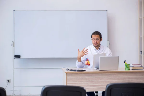 Jonge mannelijke arts geeft seminar in de klas — Stockfoto