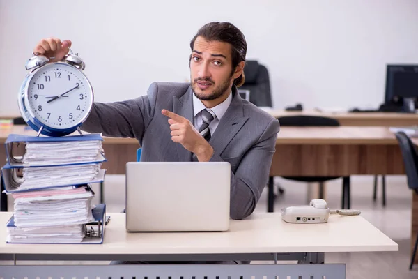 Joven empleado masculino en concepto de gestión del tiempo —  Fotos de Stock