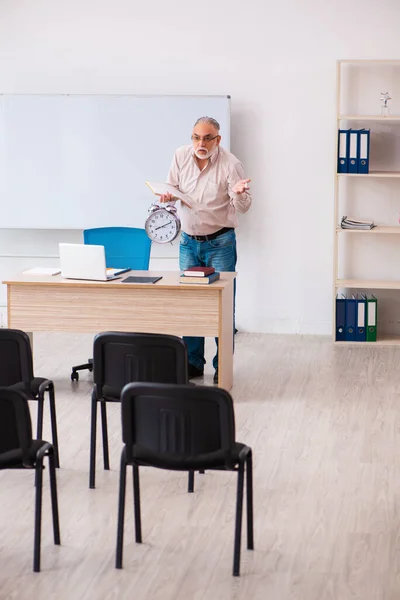 Παλιά αρσενικό δάσκαλος στην τάξη στην έννοια διαχείρισης του χρόνου — Φωτογραφία Αρχείου