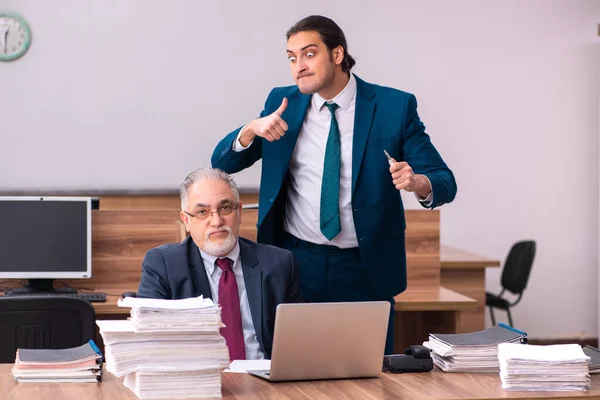 Oude mannelijke werkgever en jonge mannelijke assistent in pesten concept — Stockfoto